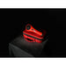 Red handheld 3b cold laser with a black cover on a dark surface