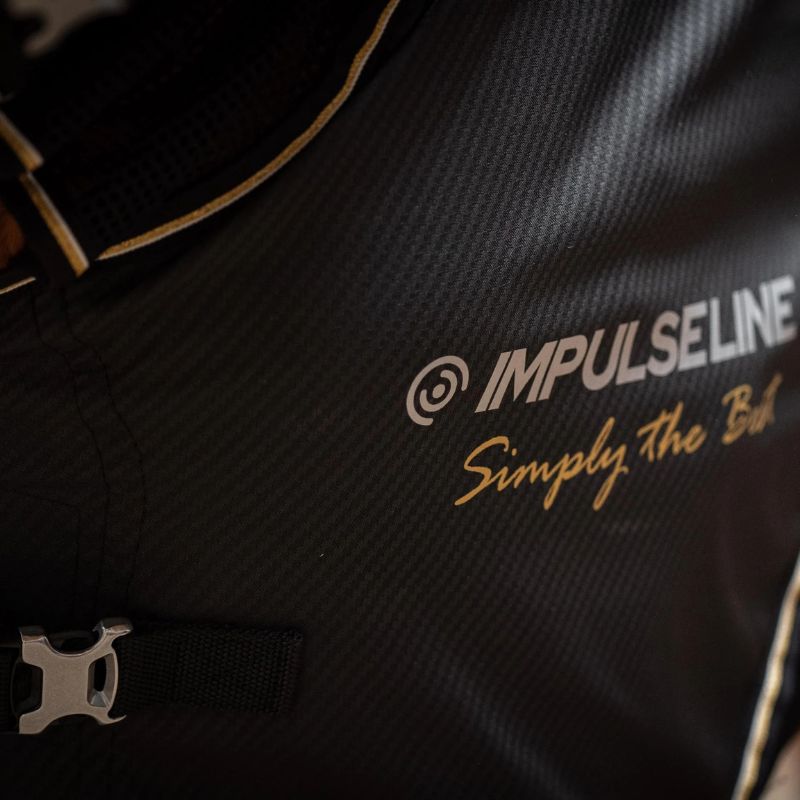 Close-up of a black bag with 'IMPULSE LINE' branding and text.