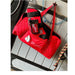Sport Innovations Red bag with visible branding on a wooden surface