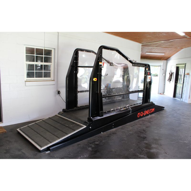 Equine treadmill in a garage setting with ramps and q-line branding in orange