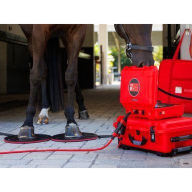 Red equine hoof care device with a horse in the background