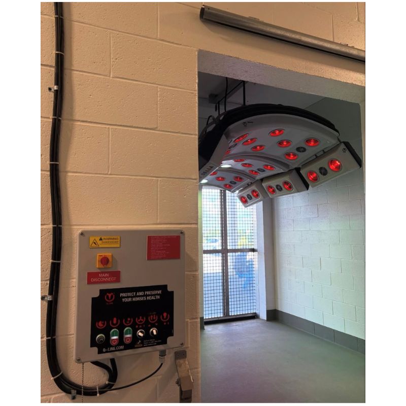 Equine Solarium with red lights mounted on a wall next to control panels.