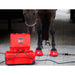 Red equine hoof care machine with a horse wearing red booties in a stable.