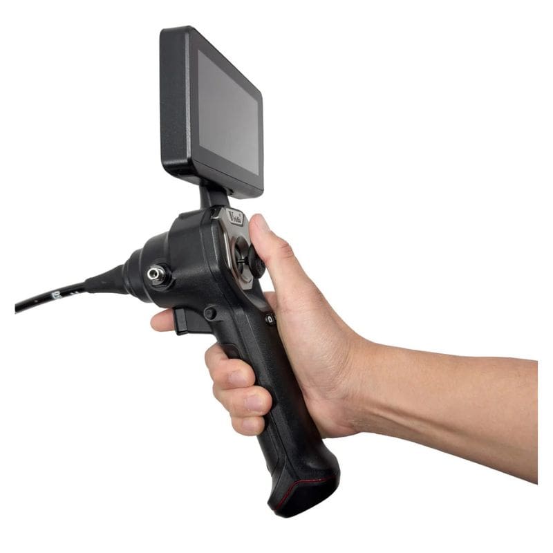 Hand holding a black industrial inspection camera with a screen on a white background
