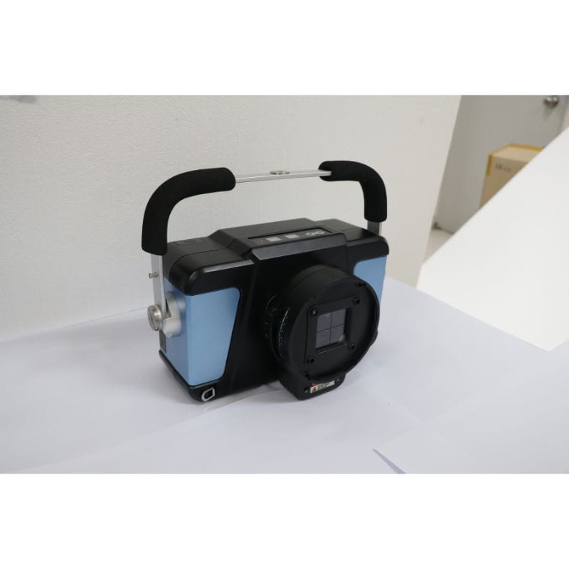 Black and blue device with a handle on a white surface