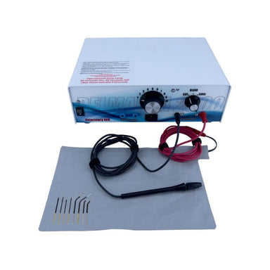 A professional tattoo ink mixing and dispensing machine kit, featuring a white and blue control box, a black mixing cup with red and black wires, several fine needle tips on a gray cloth, and a gray cleaning cloth, all set against a plain white background.